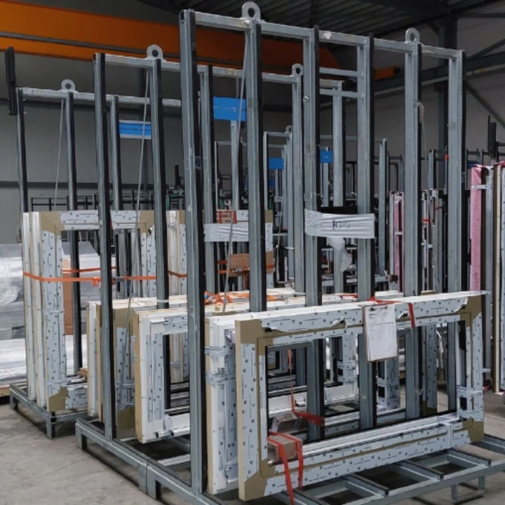 Mehrere Metall-Transportgestelle mit fixierten Bauteilen in Produktionshalle